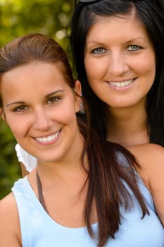 Portrait of mother and daughter smiling outdoors teen relaxing love