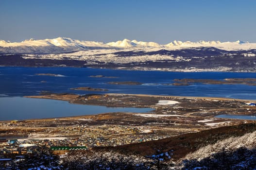 Ushuaia with the Beagle Channel and snow covered mountains behind it.