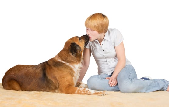 Young attractive affectionate woman sitting on the floor kissing her large gentle dog on the nose with copyspace