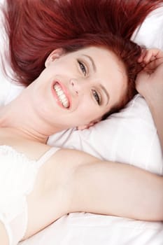 Attractive young woman lying on her bed in her underwear at home