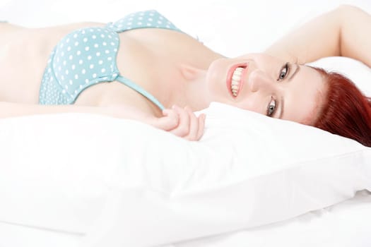 Beautiful young woman resting on her bed at home in her underwear