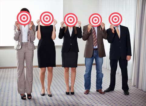 Group of business people holding a target against their faces