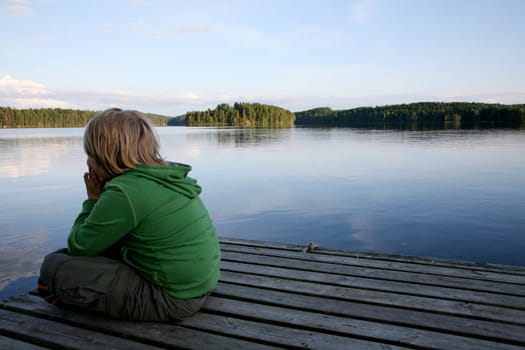 Boy sitting by the lake