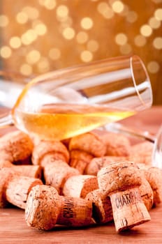 A glass of Champagne over corks on a table
