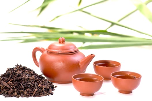 Chinese tea in clay cup close up with tea set and chinese tea background