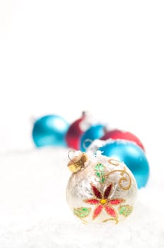 Red, blue and colourful Christmas baubles on snow