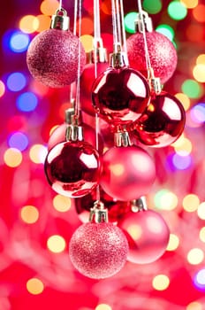 Red Christmas hanging baubles with lights and decorations at the background