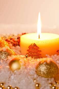 Gold Christmas candle flame with gold decoration on snow