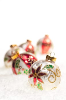 Colourful Christmas baubles close up on snow