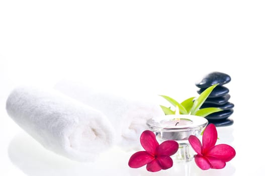 Spa concept with black zen stones and red flowers over white background