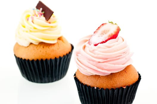 Strawberry and vanilla cupcake close up over white background