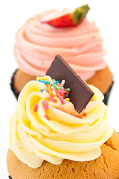 Vanilla and strawberry cupcake close up over white