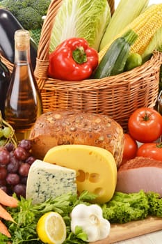 Composition with groceries in wicker basket on kitchen table