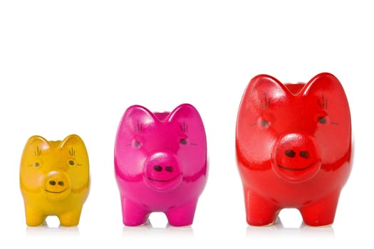 Growing investment concept.Three piggy banks of increasing size over a white background.