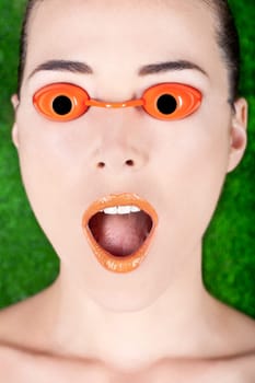 Closeup portrait of a surprised beautiful woman wearing tanning bed glasses with mouth open