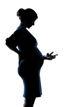 beautiful caucasian pregnant woman baby bottle in silhouette on studio isolated white background