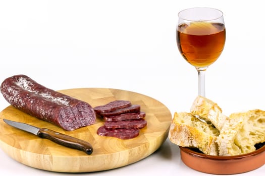 Iberian sausage sausage on a wooden board, with a glass of wine, and sliced ??rustic bread.