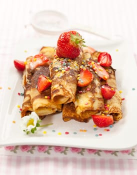 Rolled crepes with fresh strawberries and jelly