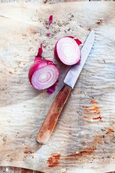 Sliced red onion with an old knife on a vintage background. For italian cuisine concepts