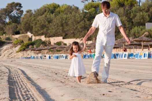 Cheerful family father with little daughter on vacation at the beach in summer