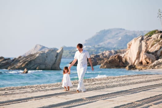 Cheerful family father with little daughter on vacation at the beach in summer