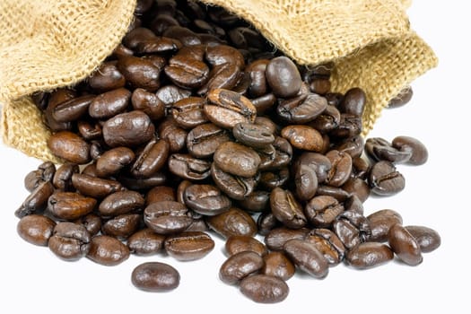 Roasted coffee beans in jute sack on white background