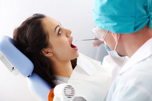 A female patient sitting in the dental chair with her mouth open