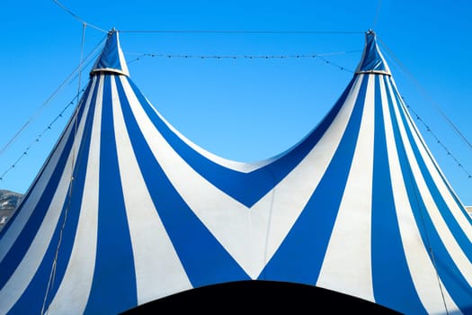 Circus tent stripped blue and white over clear sky