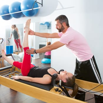 Pilates aerobic personal trainer instructor man in cadillac fitness woman exercise
