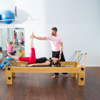 Pilates aerobic personal trainer instructor man in cadillac fitness woman exercise