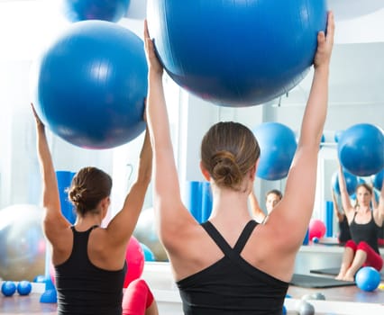 Blue stability ball in women Pilates class rear mirror view