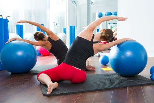 Blue stability ball in women Pilates class rear mirror view