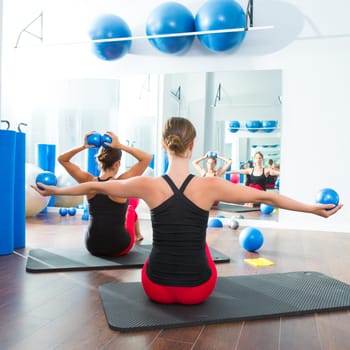 Pilates toning ball in women fitness class rear mirror view