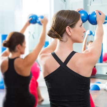 Pilates toning ball in women fitness class rear mirror view