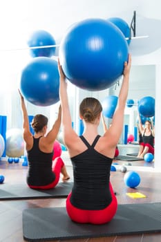 Blue stability ball in women Pilates class rear mirror view