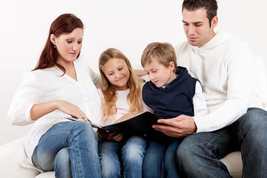 Hapy young family watching photo album at home