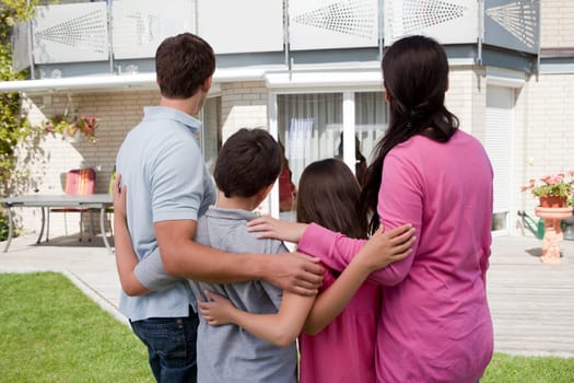 Buying new home - Family standing in front of their new house