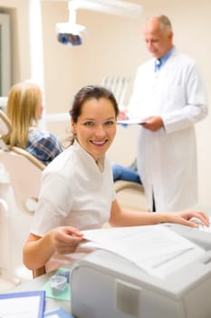 Dental assistant smiling woman prepare patient documentation stomatology clinic