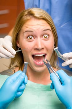 Scary dental tools crazy woman patient at the dentist