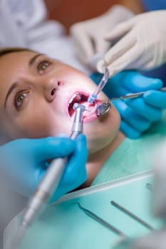 Close-up of open mouth at dental surgery with tools