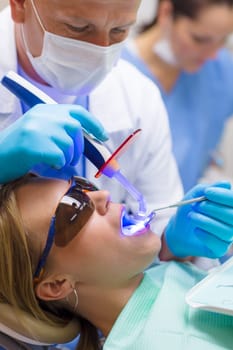 Young woman having dental professional dental treatment in stomatology clinic