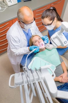 Professional dentist with nurse check patient teeth top view portrait