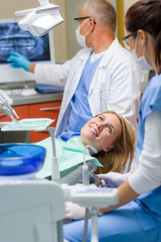 At the dentist happy woman after dental treatment lying chair
