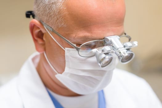 Portrait of mature dentist surgeon wear special glasses technology equipment