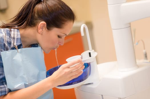 Dental patient woman spit water after treatment at stomatology clinic