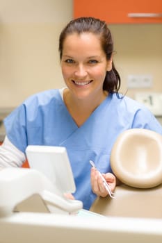 Smiling dentist woman prepare dental tools at modern surgery office