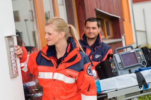 Paramedics house call visit ambulance help ringing woman man assistance