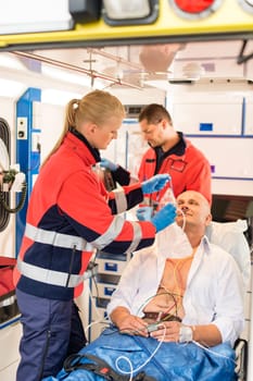 Paramedic putting oxygen mask on patient ambulance sick emergency