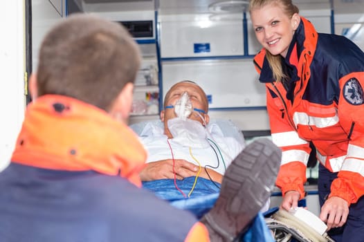 Patient in ambulance car with paramedics rescue aid emergency man