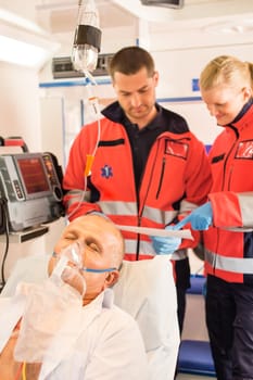 Paramedics reading EKG in ambulance patient help emergency woman man